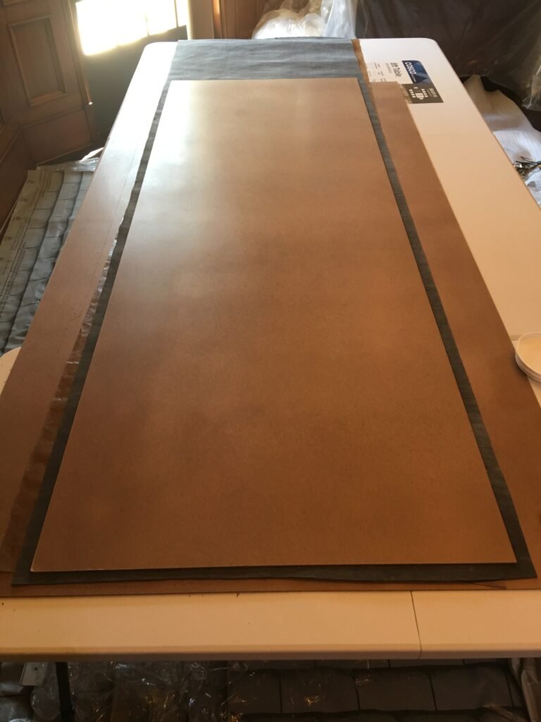Wallpaper sheet measured and cut on a pasting table