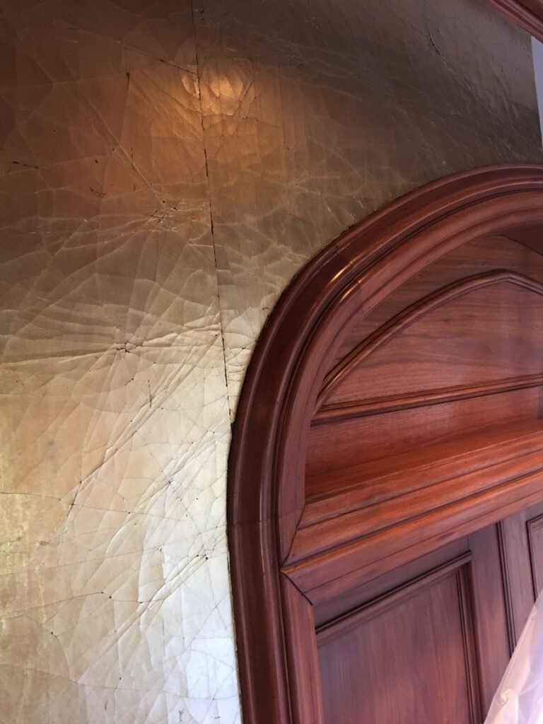Installer hanging wallpaper at height on a job site