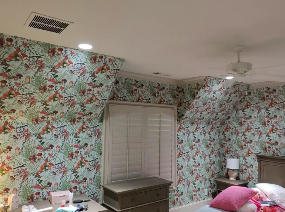 Bedroom featuring woodland patterned wallpaper with birds and foliage on walls and sloped ceiling dormers.